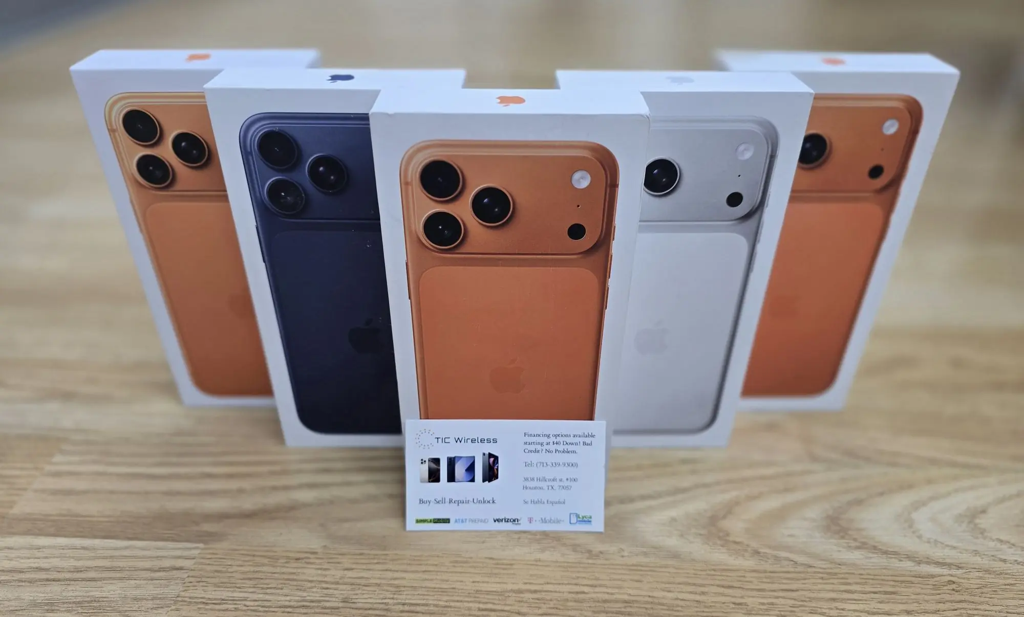 Boxed iPhone 17 Pro phones with a TIC Wireless Electronic & Repair Center business card