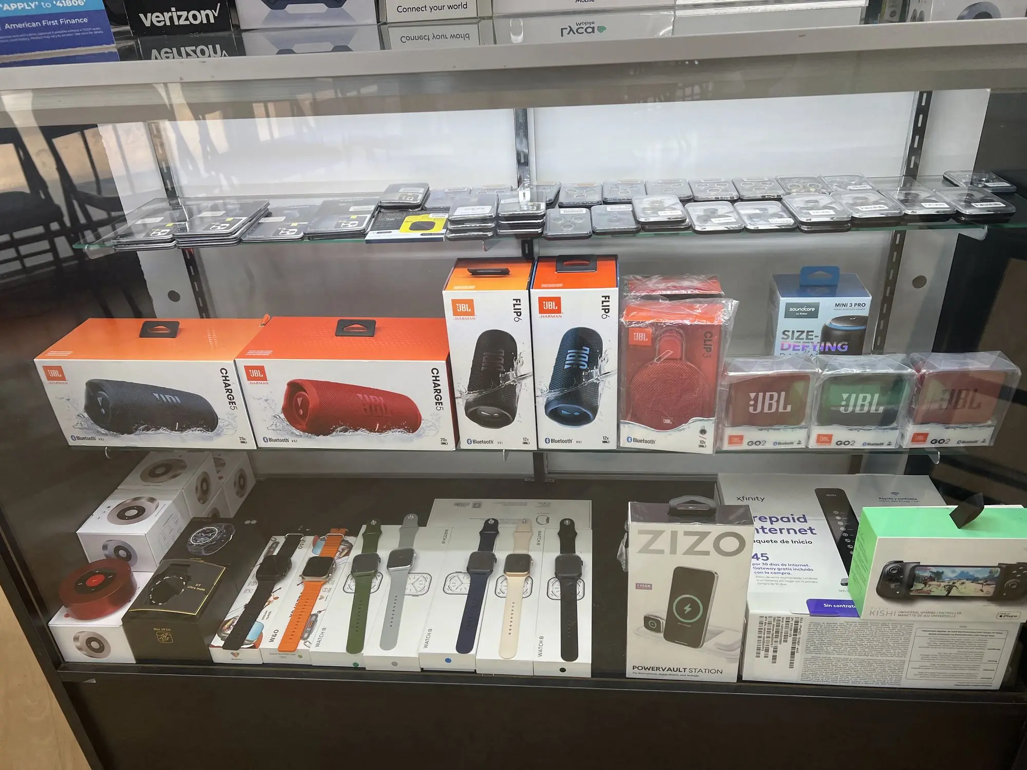 Bocinas JBL, relojes inteligentes y cargadores en una vitrina