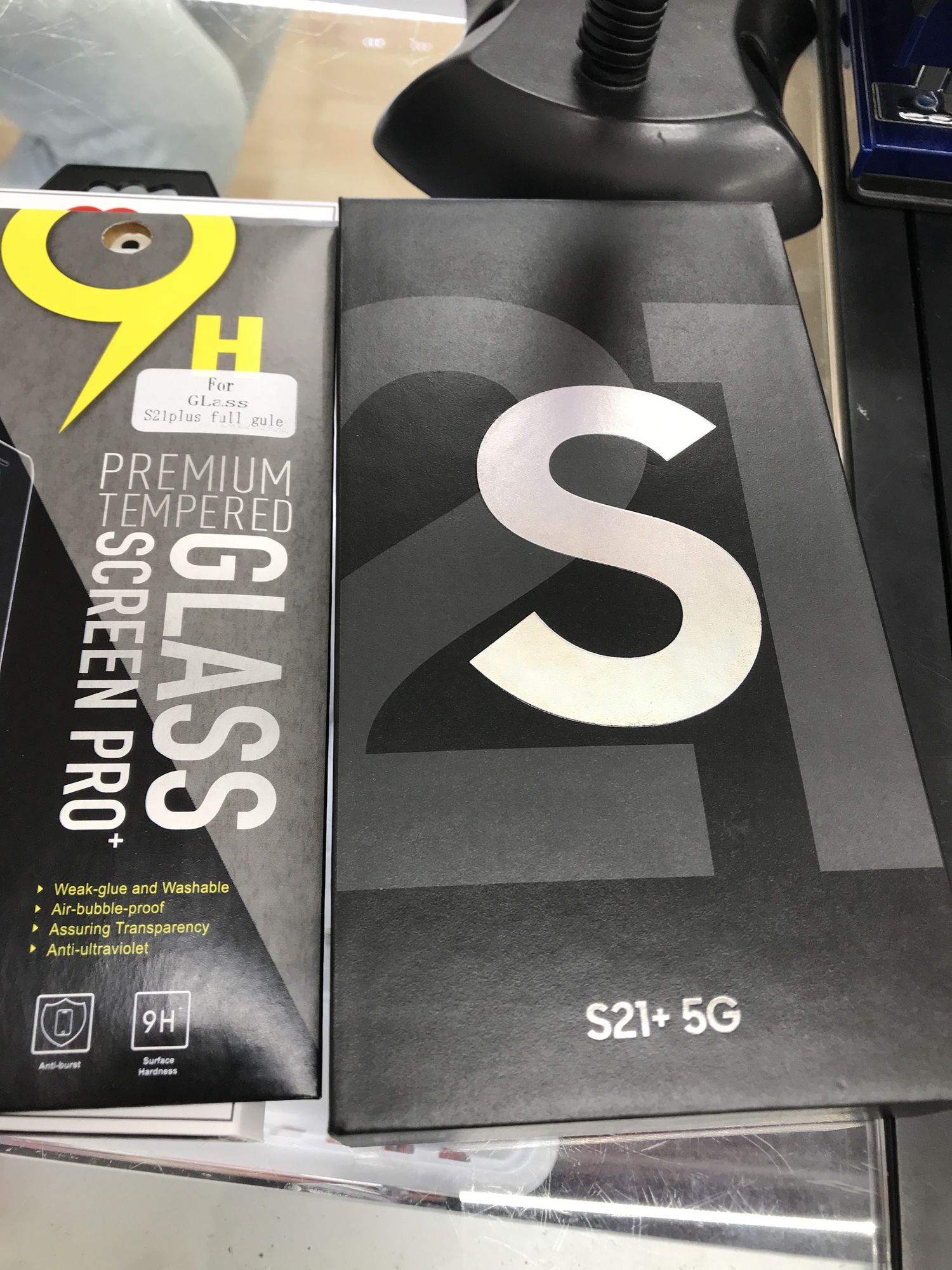 Premium 9H tempered glass screen protector next to a Samsung Galaxy S21+ box