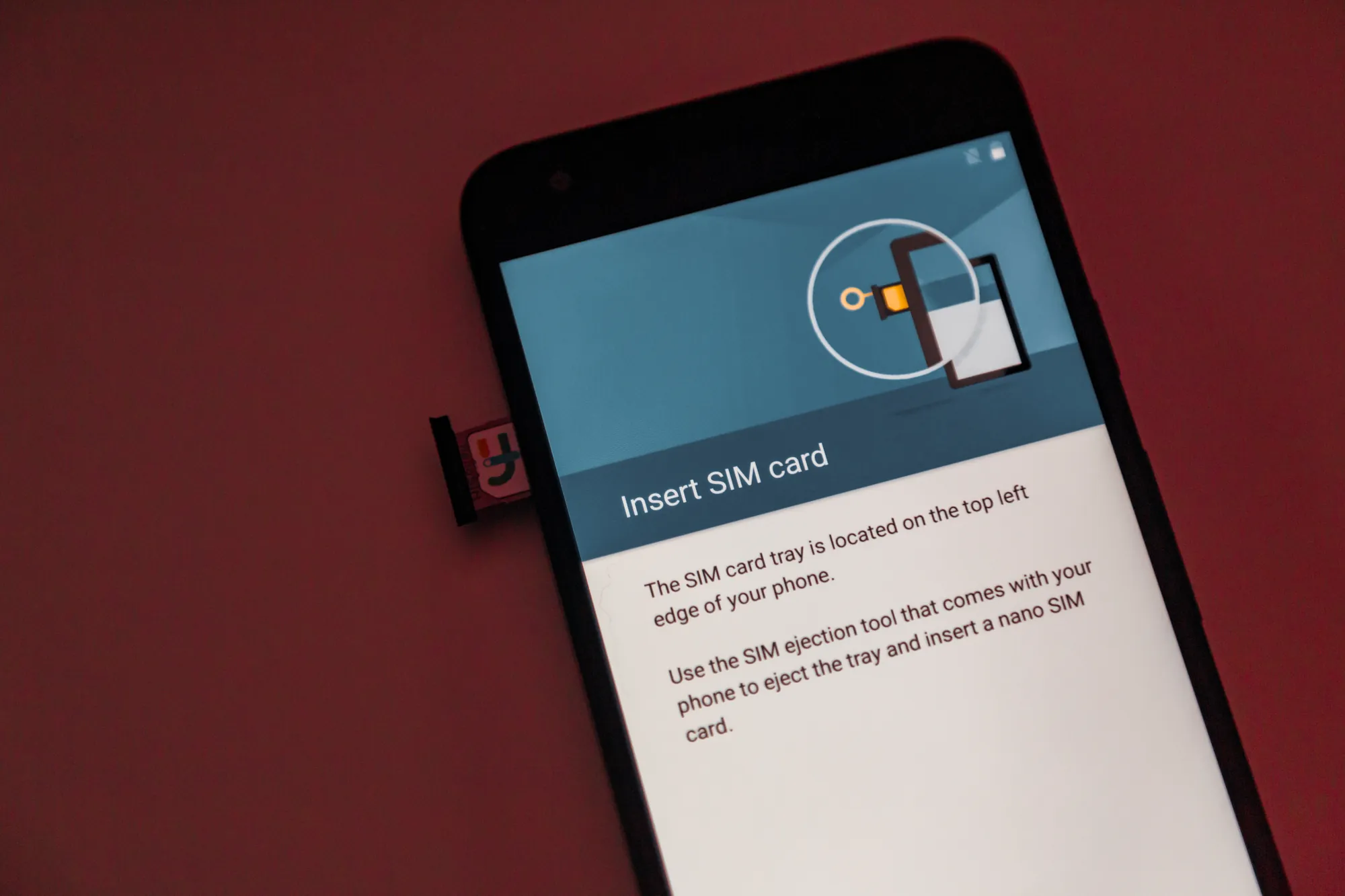 A phone showing the Insert SIM card screen with its SIM tray ejected